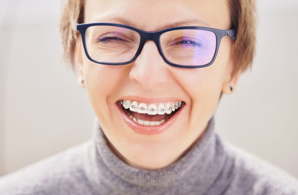 Smiling adult with braces laughing in a close-up view